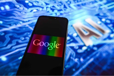 In this photo illustration, a Google logo displayed on a smartphone with Artificial Intelligence (AI) design in the background. google has been working on using its AI to create a virtual life coach
