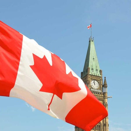 Canadian flag waving in front of the Parliament Building on Parliament Hill in Ottawa. A new AI-generated travel article suggested tourists visit the Ottawa Food Bank.
