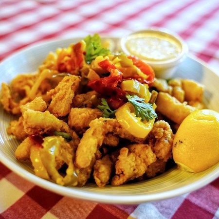 rhode island style calamari in a white bowl on a white and red checkered tablecloth