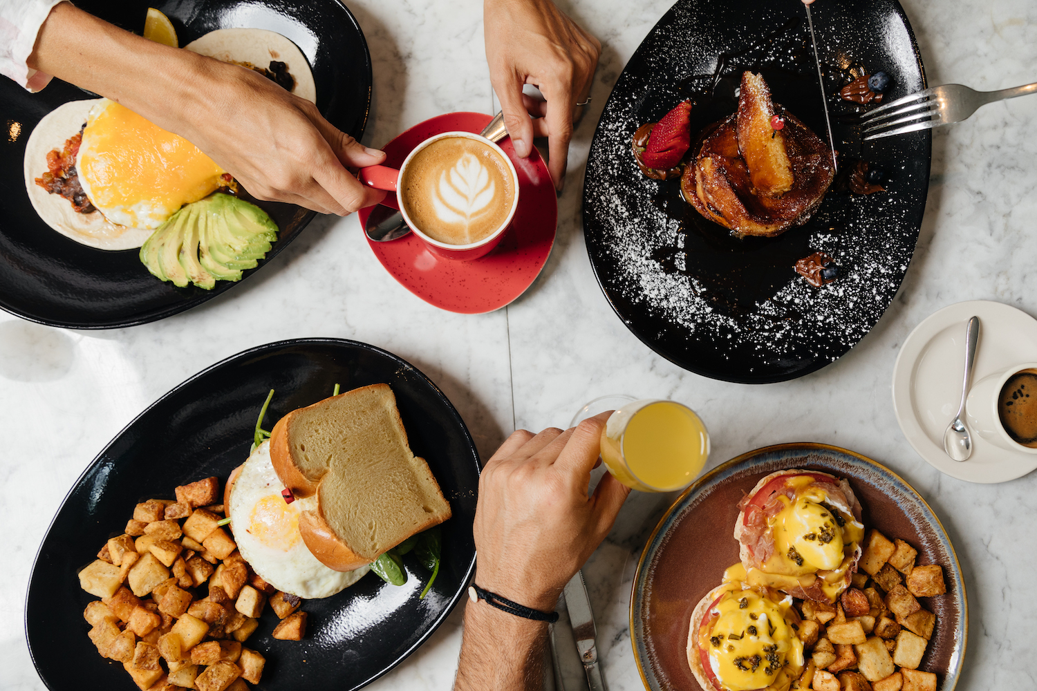 Spread of brunch foods on a table from a bird's-eye view