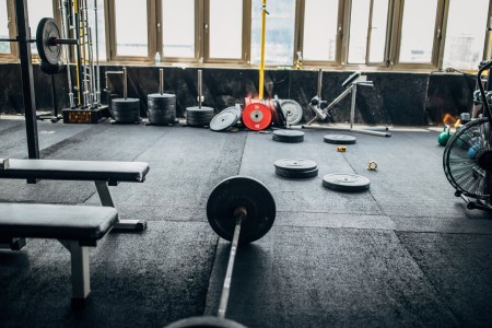 The gym floor at a cross-training studio, with barbells and weights.