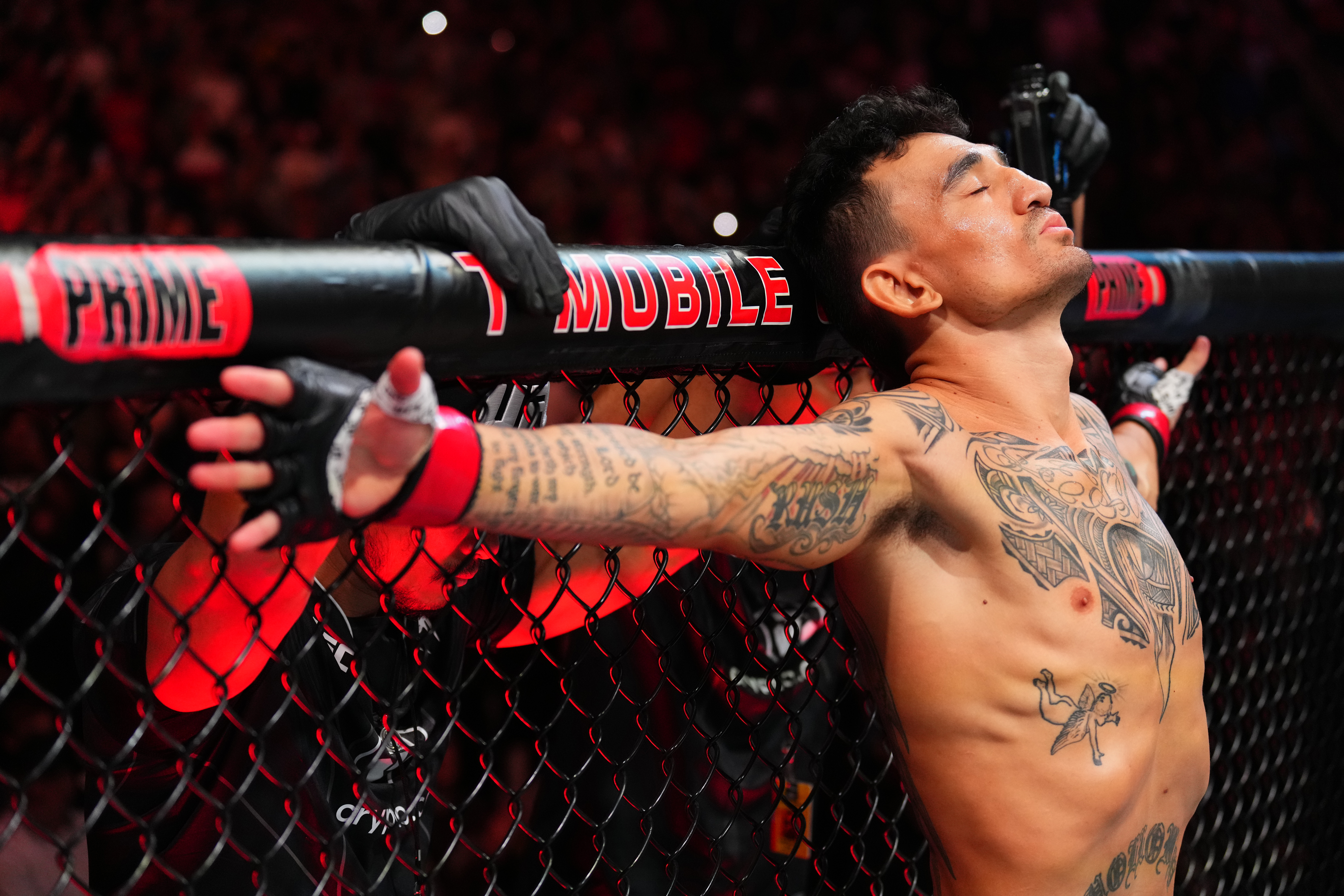 A photo of Max Holloway in the UFC Octagon with his arms spread out to either side.