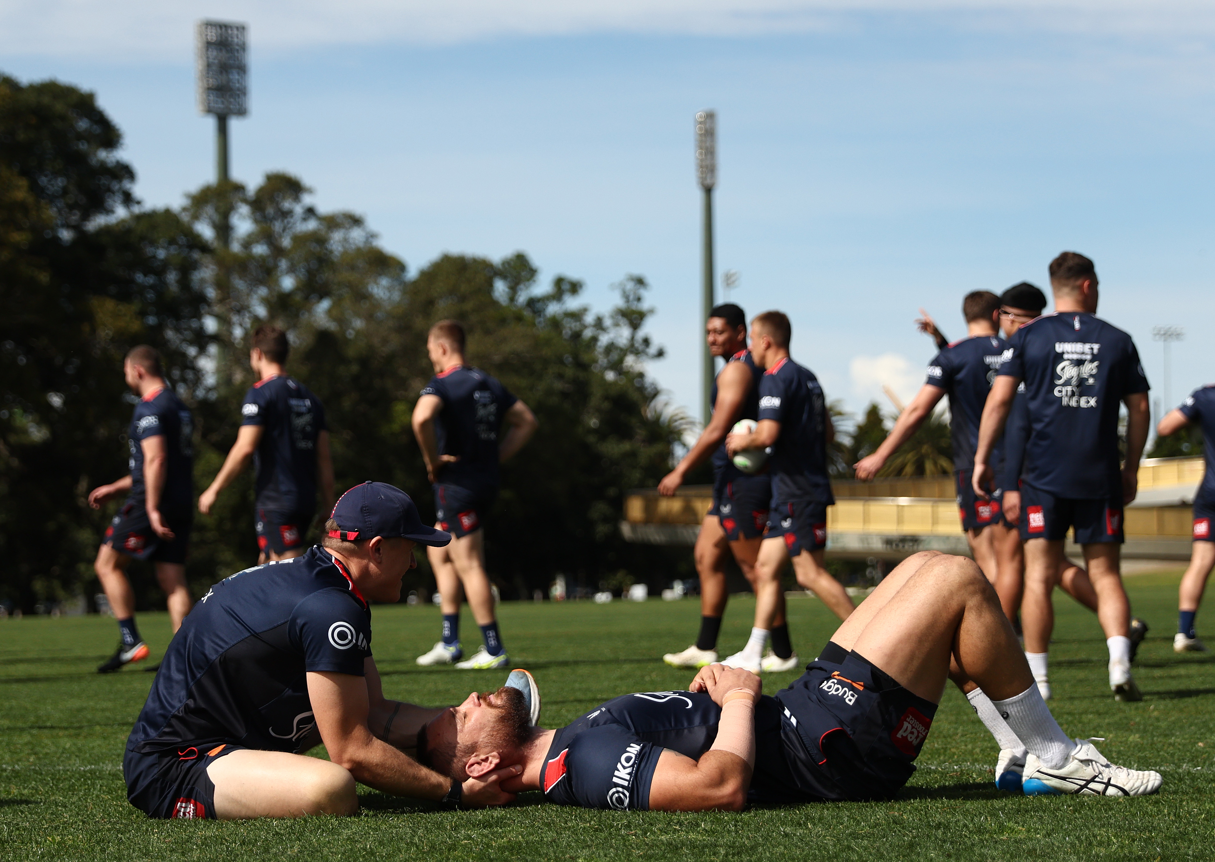 A rugby player getting his neck massaged.