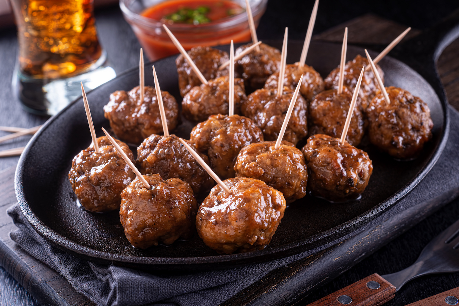 A platter of delicious sweet and spicy meatballs with toothpicks