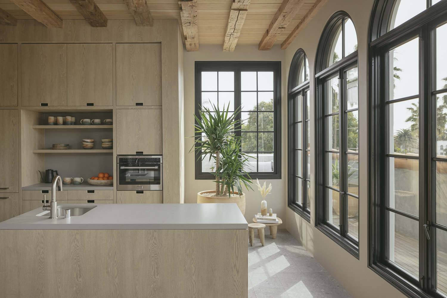 Kitchen area with tall windows and brown aesthetic 