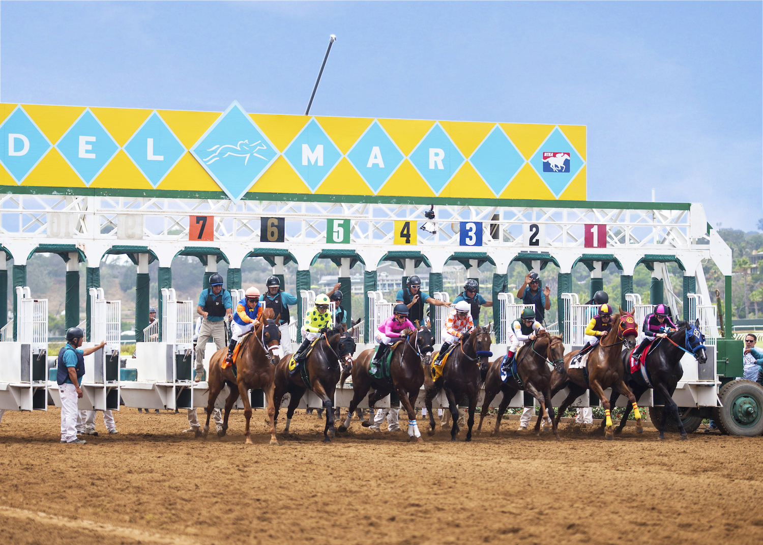 Horses galloping out of the starting gate at the Del Mar Racetrack in California