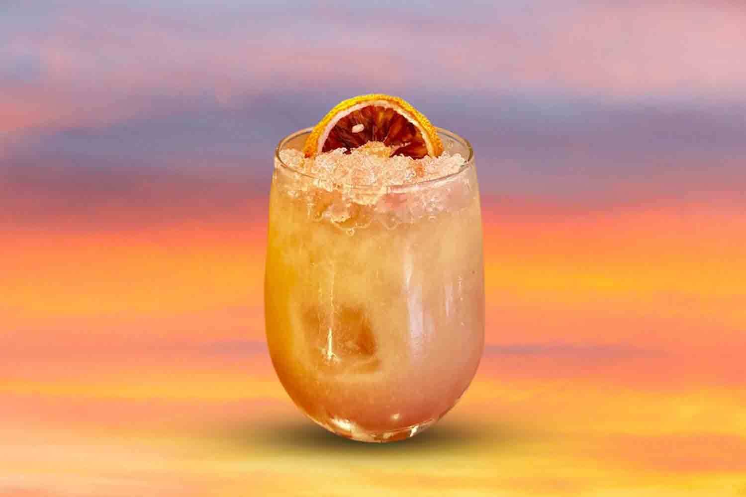a tequila sunrise cocktail on a wooden table