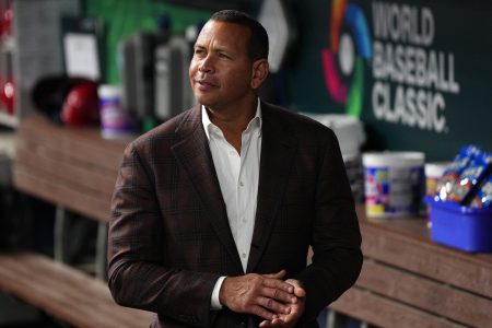 Ex-MLB player Alex Rodriguez walks in the dugout.