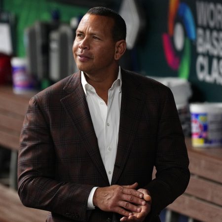 Ex-MLB player Alex Rodriguez walks in the dugout.