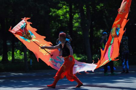 A Chinese man dancing with a dragon.