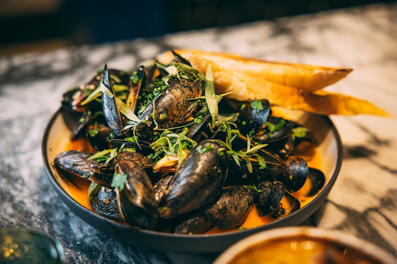 Mussels in a dish with bread slices