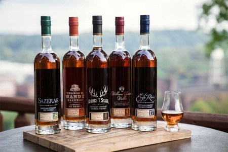 Buffalo Trace Antique Collection 2023 on a table outside with a tasting glass of whiskey