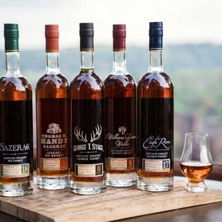 Buffalo Trace Antique Collection 2023 on a table outside with a tasting glass of whiskey
