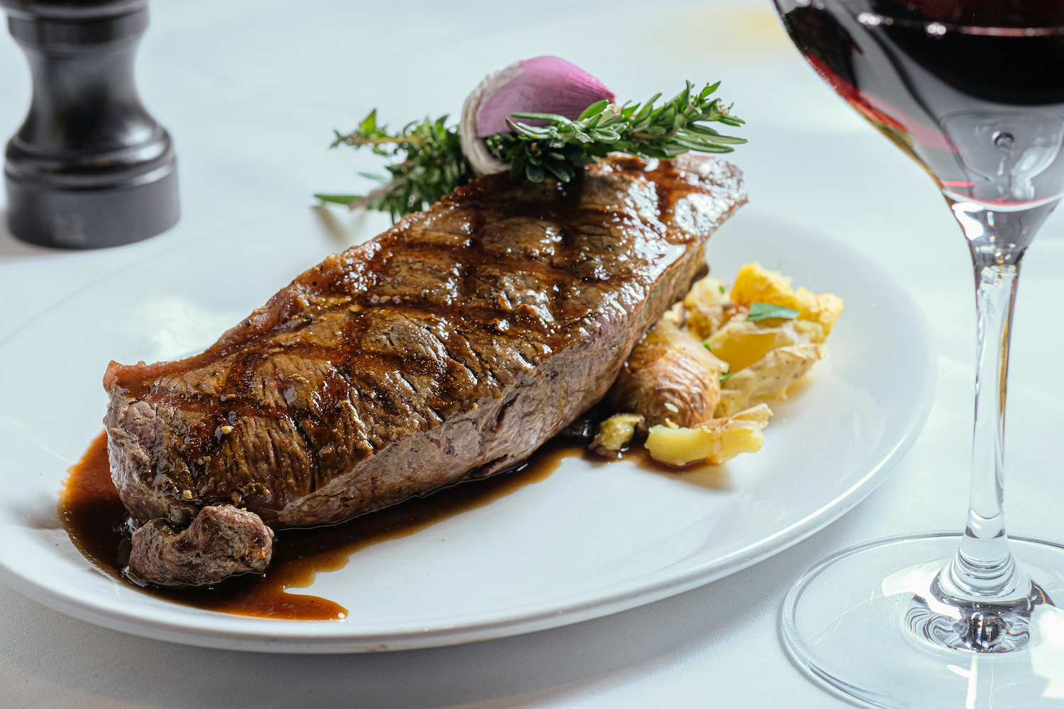 Steak and potatoes on a plate with red wine