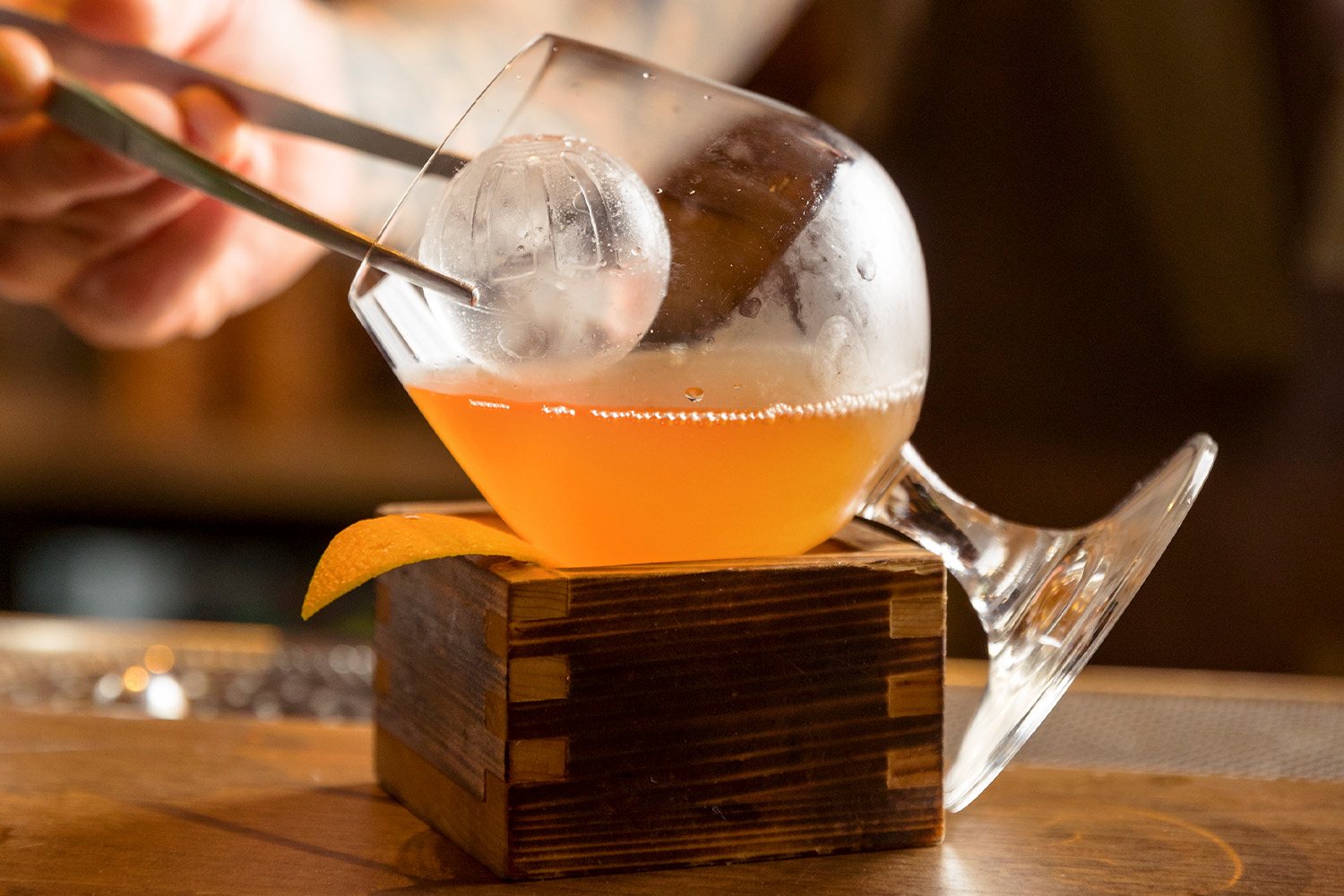 Orange whiskey in a glass with sphere ice