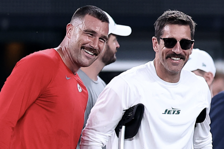 Travis Kelce talks with an injured Aaron Rodgers at MetLife Stadium.