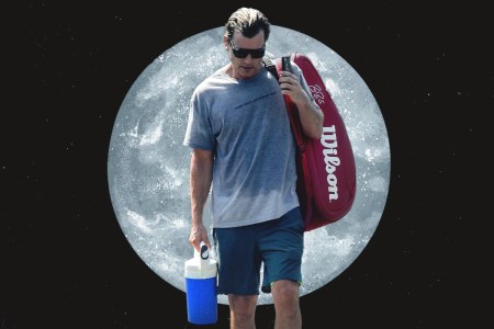 A man walking with a huge water bottle, with the moon behind him.