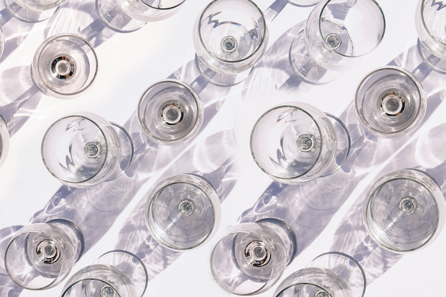 a crowded table of empty white wine glasses