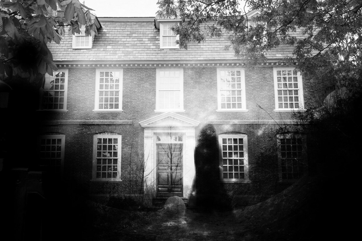 spooky black and white photo of a shadowy figure outside of an old house