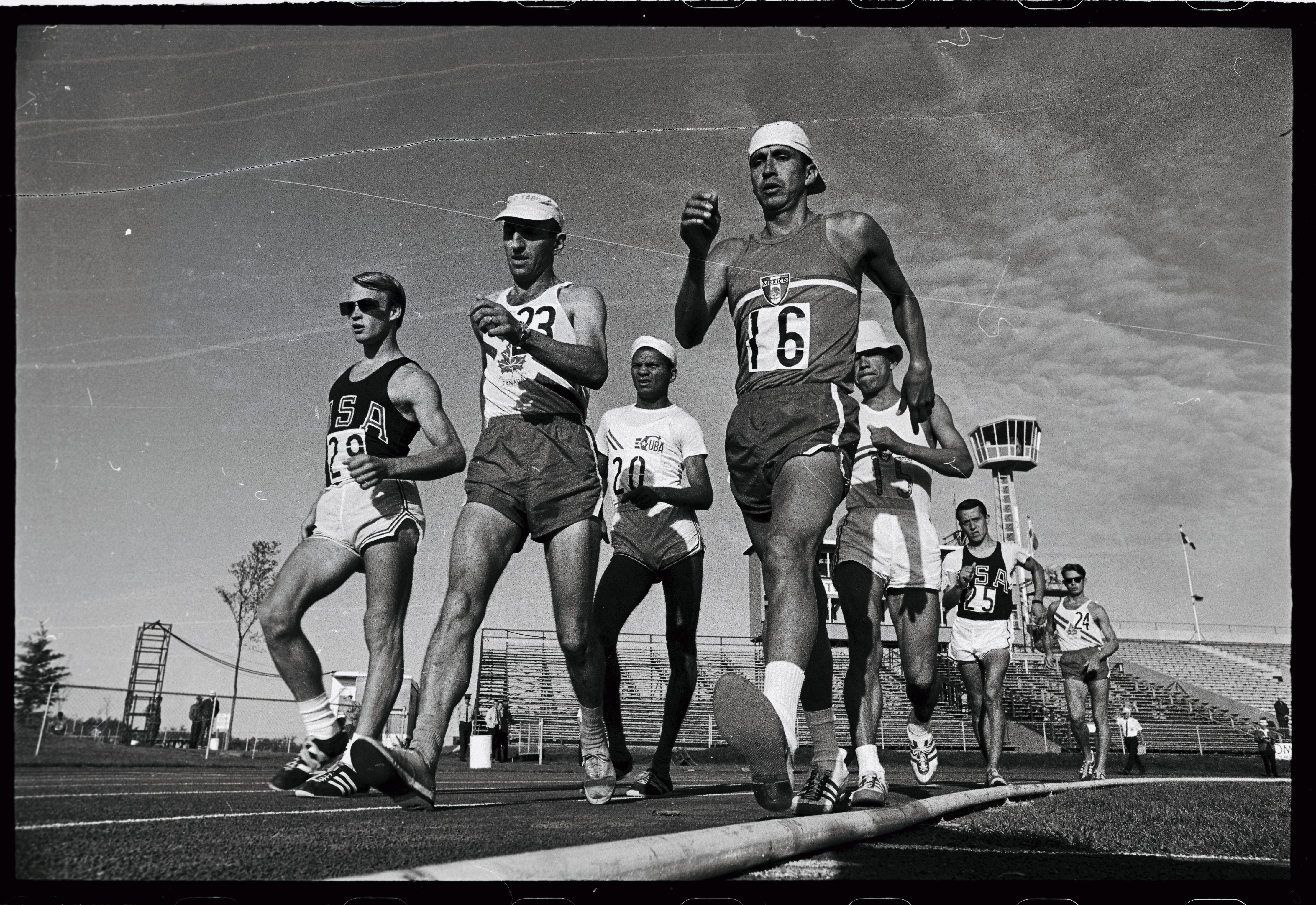A group of runners in singlets walking. Black and white photo.