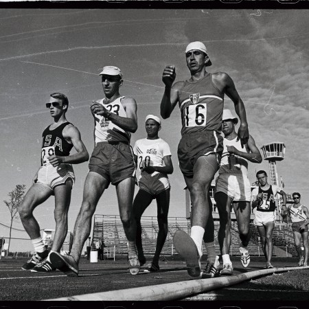 A group of runners in singlets walking. Black and white photo.