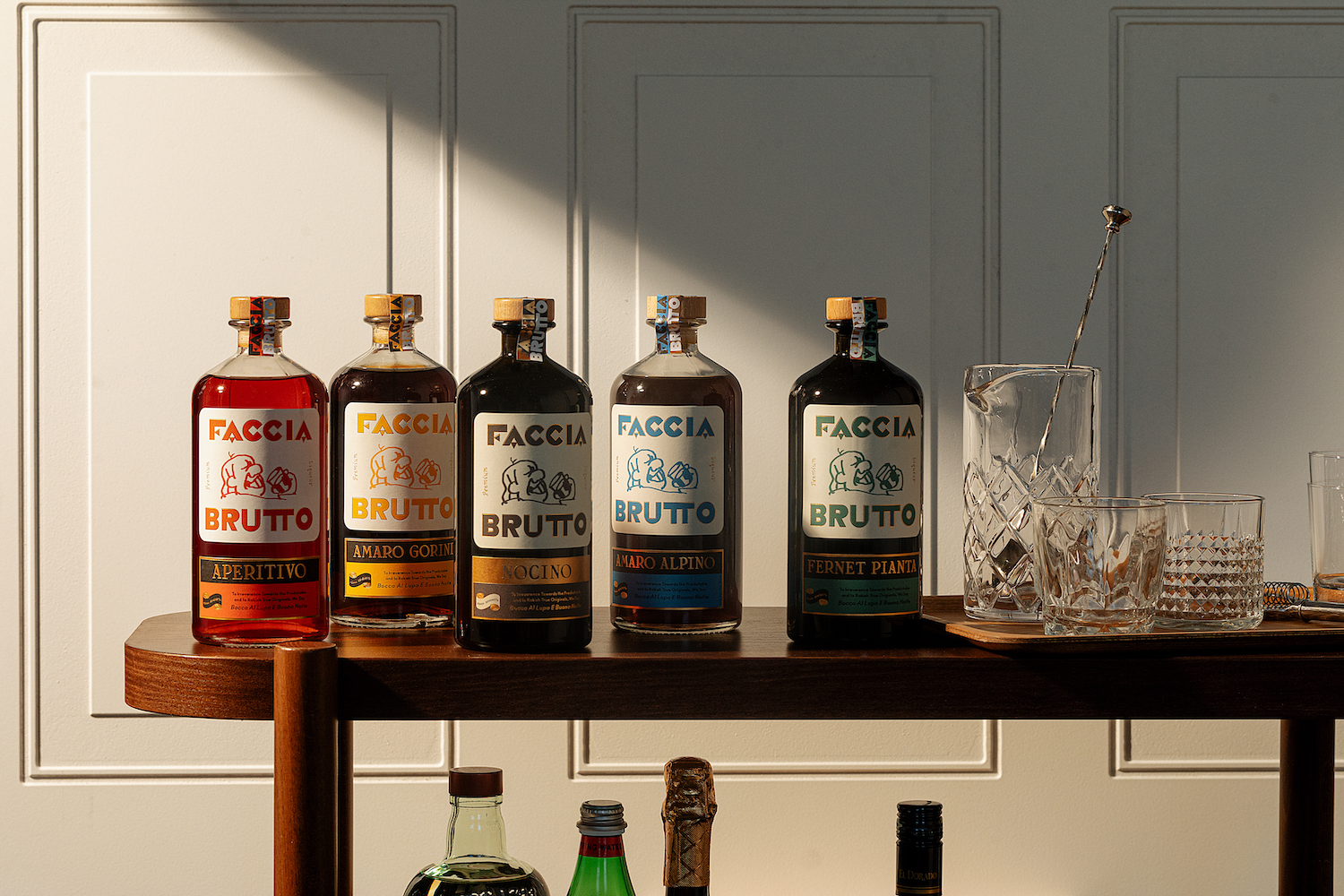 lineup of faccia brutto bottles on a thin wooden table with natural light