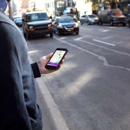 A person using the rideshare app Lyft. Lyft now says they will pay passengers in Lyft credits if drivers are late to scheduled pickups.