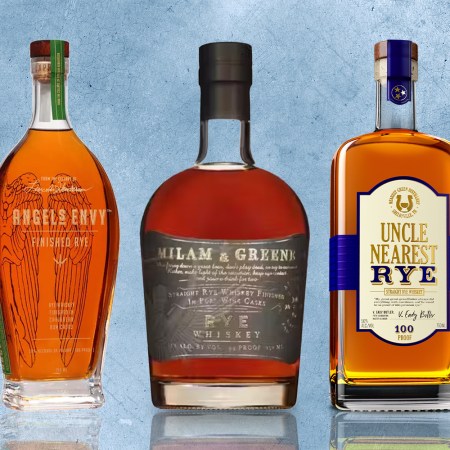 lineup of three bottles of rye whiskey on a blue textured background
