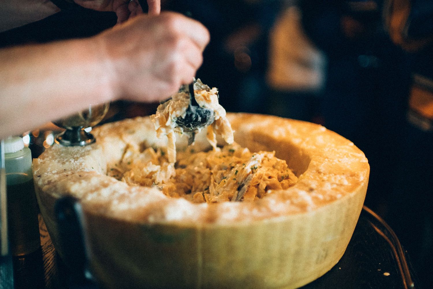 Man twirling pasta in large bowl