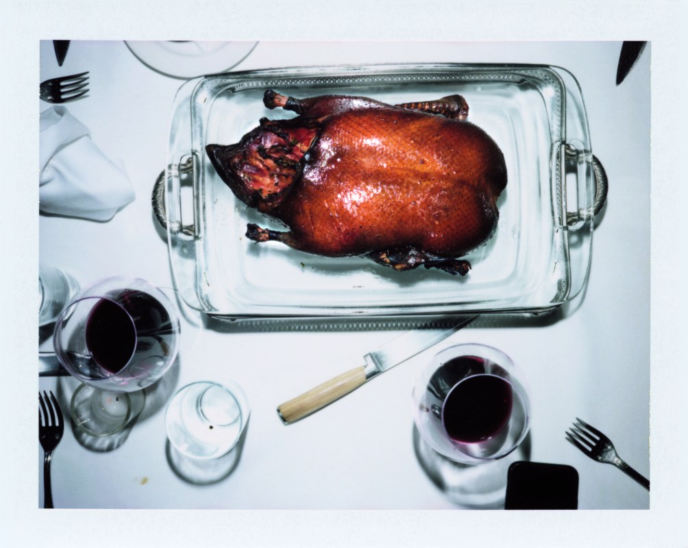 ROAST DUCK FLAMBÉ on a silver platter table with white tablecloth