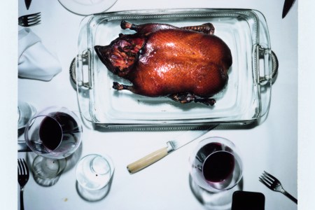 ROAST DUCK FLAMBÉ on a silver platter table with white tablecloth