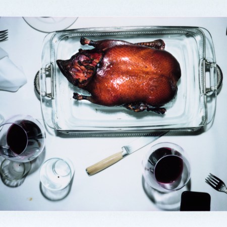 ROAST DUCK FLAMBÉ on a silver platter table with white tablecloth