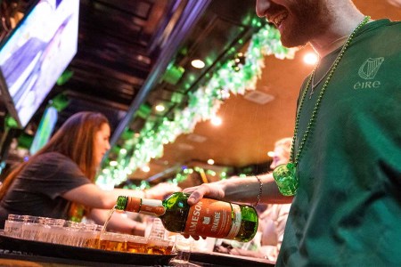 A waiter pours shots of whiskey at the Playwright Irish Pub near Times Square after the St. Patrick’s Day parade on March 17, 2022 in New York City. Irish whiskey brands are trying to figure out how to spread the word about their whiskey on days outside of March 17.