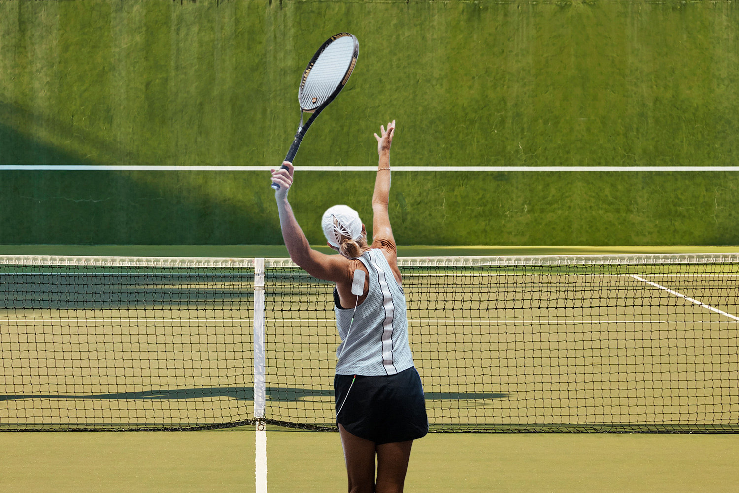 A photo of a woman preparing to serve a tennis ball.