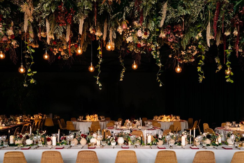 Long table in dark room decorated with flowers and dim lights