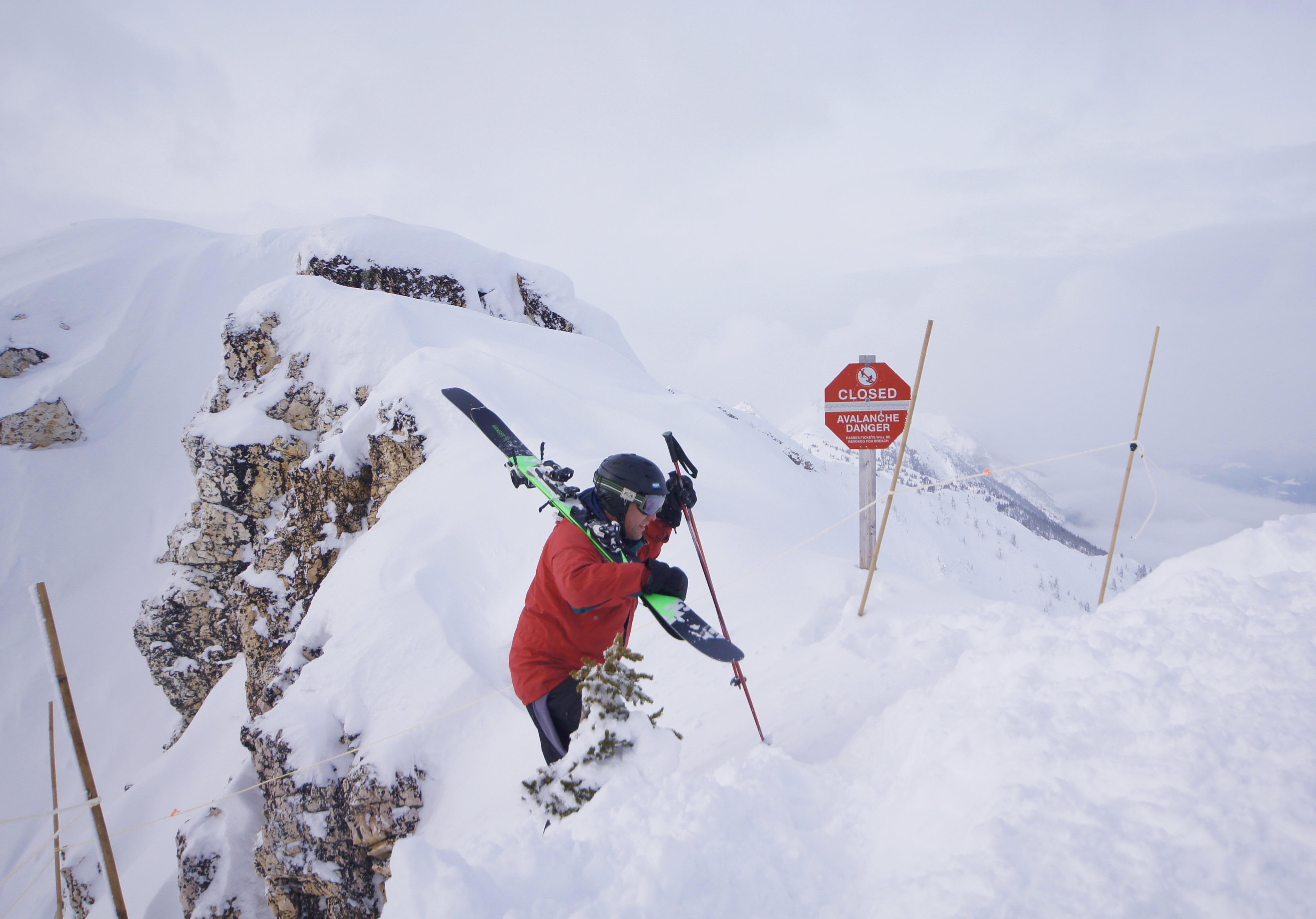A skier trudges through feet of snow on a mountain.