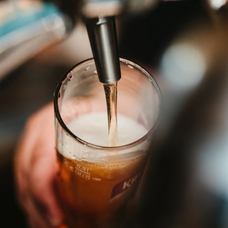 A bartender pouring beer from a tap. Beer sales are down year to year.