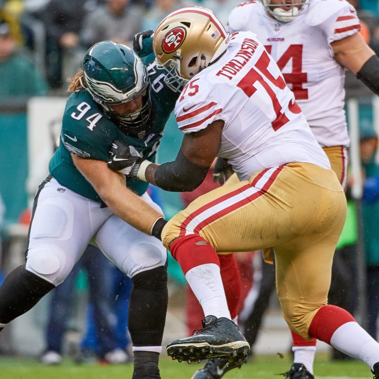 Eagles and 49ers linemen battle during an NFL football game.