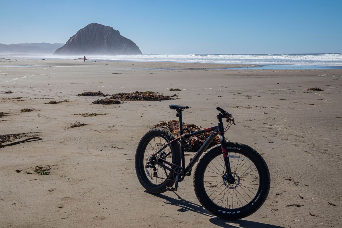 A fat tire bike parked on a beach in California.