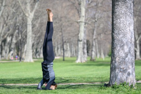 A woman doing a headstand in a park.