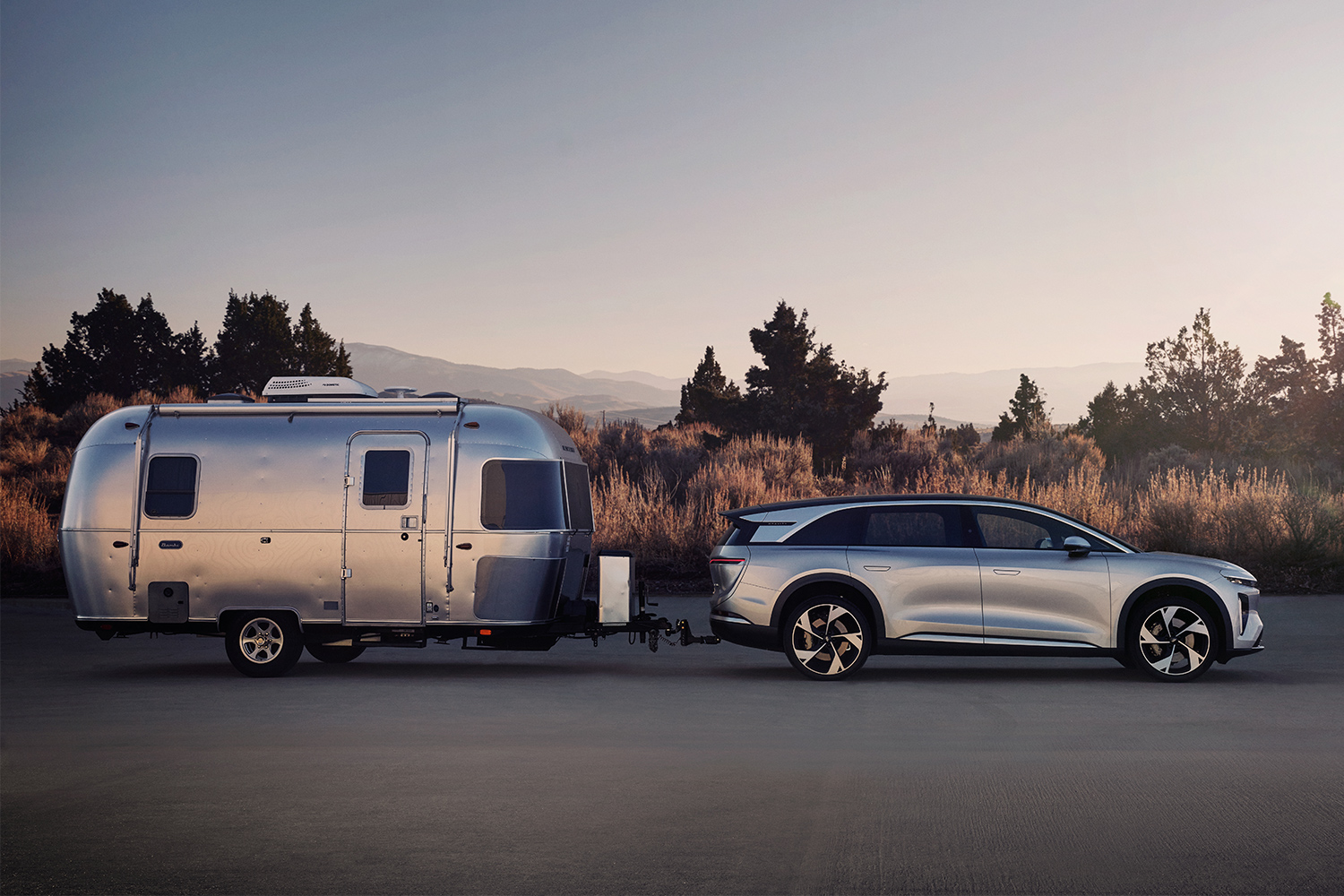 An electric SUV towing an Airstream trailera