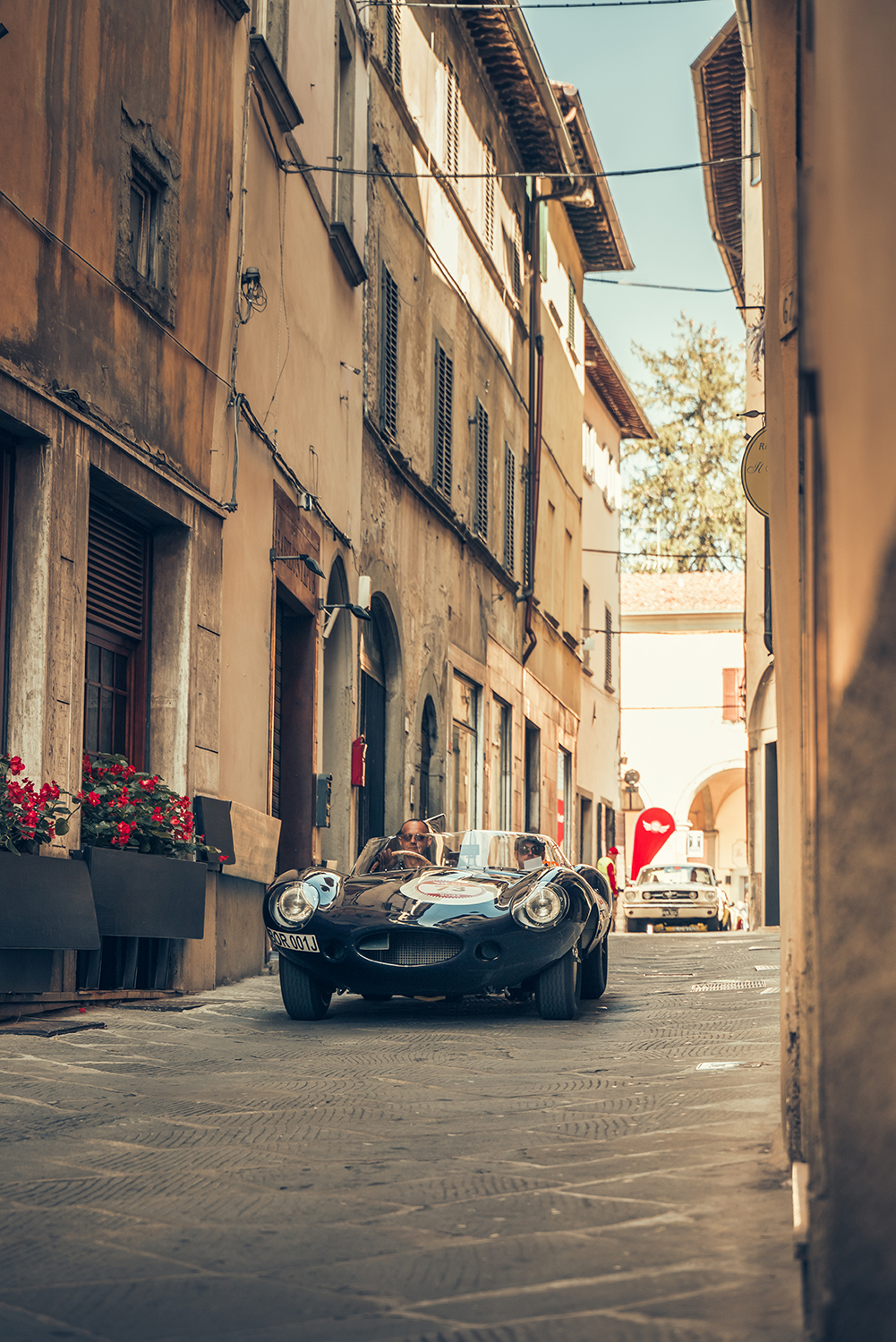 Classic cars driving through a city in Italy