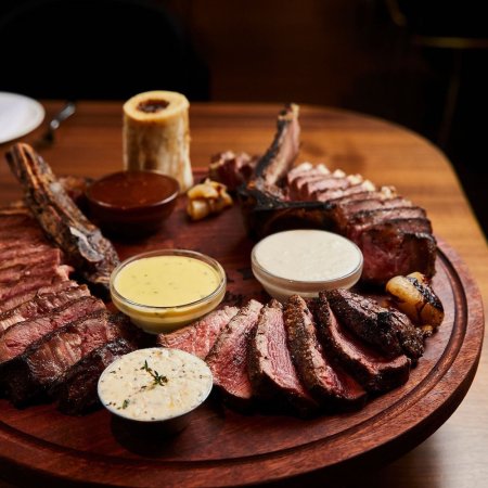 Board with steak and sauces