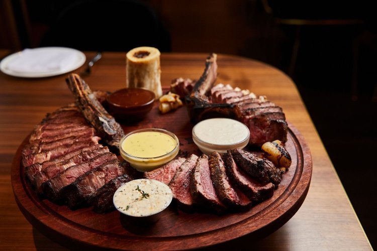 Board with steak and sauces