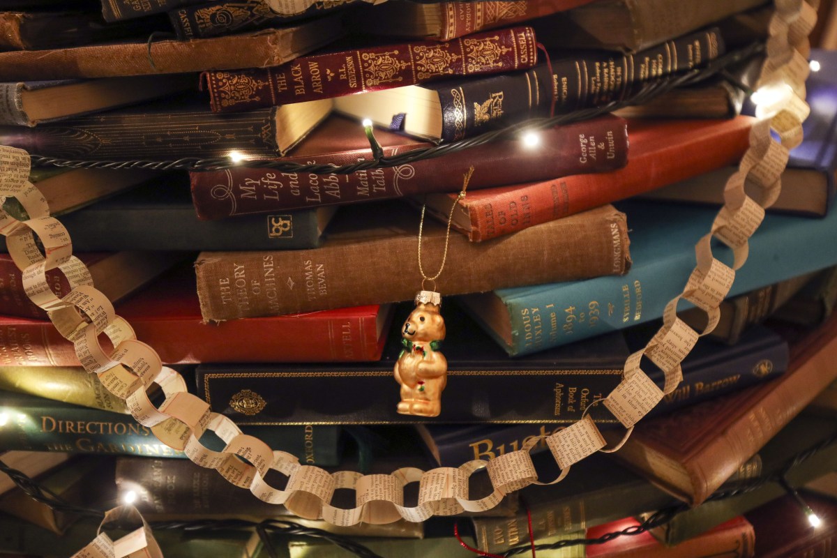 Books piled up in the shape of a Christmas tree.