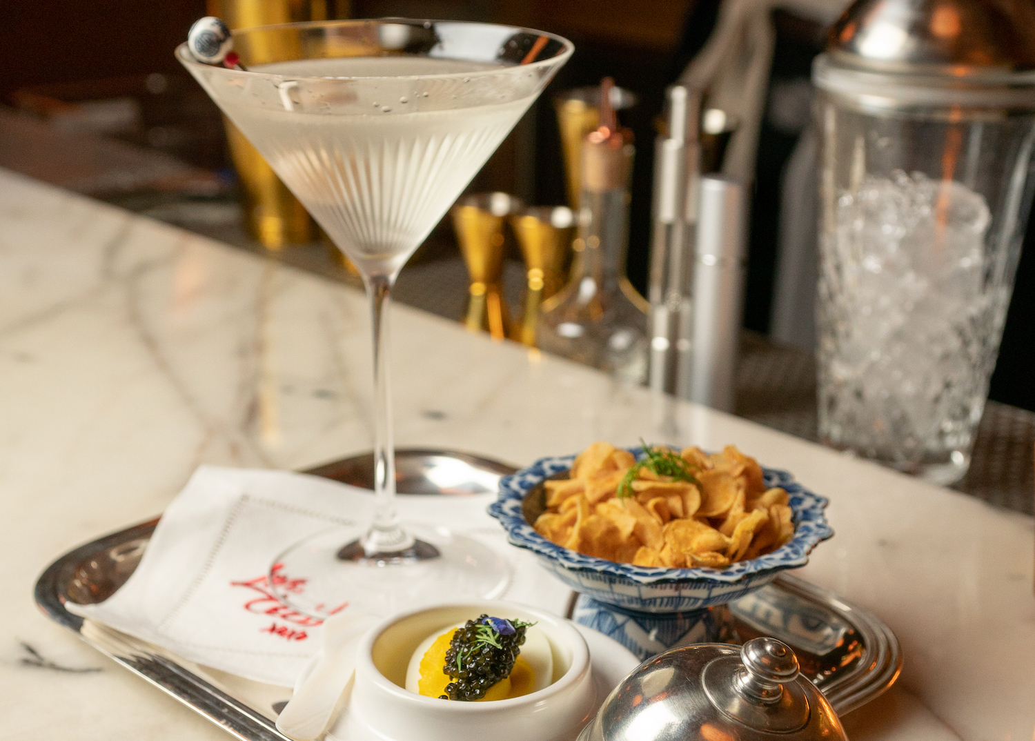 Bar Cecil's $50 martini, deviled egg topped with caviar and side of sunchoke chips