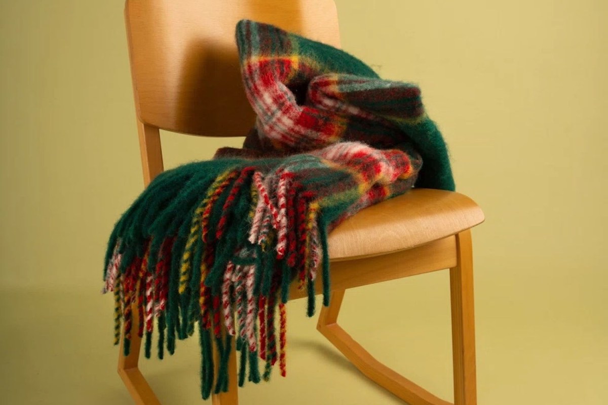 A woolrich throw blanket on a wooden chair