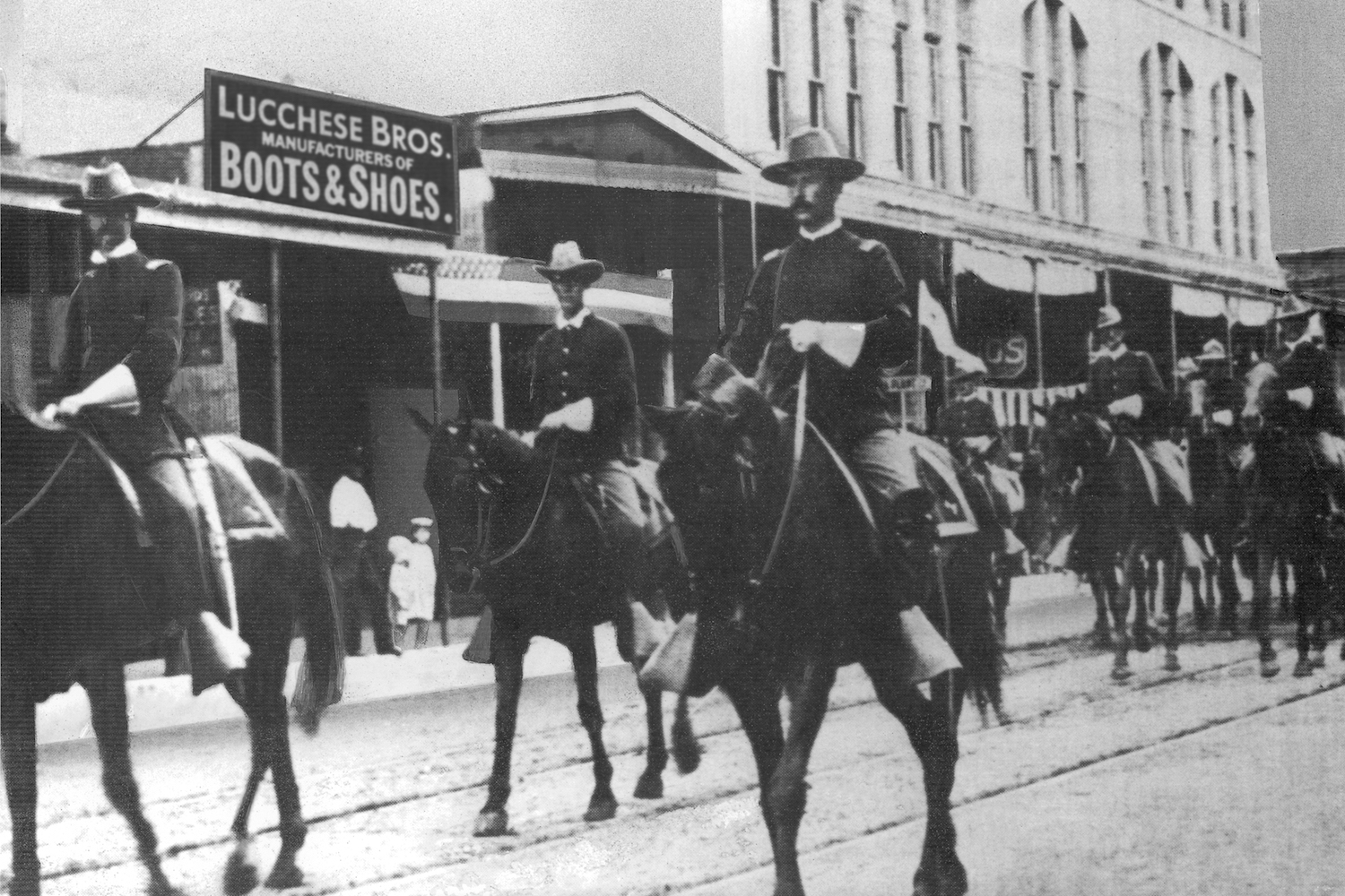 The First Reg. Texas Volunteer Cavalry marches in front of Lucchese Bros. Store in San Antonio in 1889