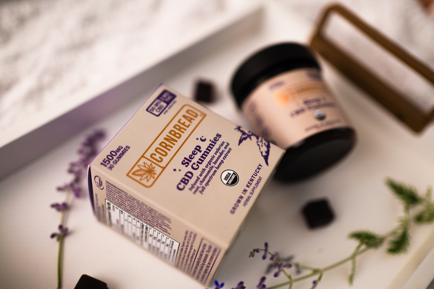 cornbread hemp cbd gummies on a white tray with lavender sprigs