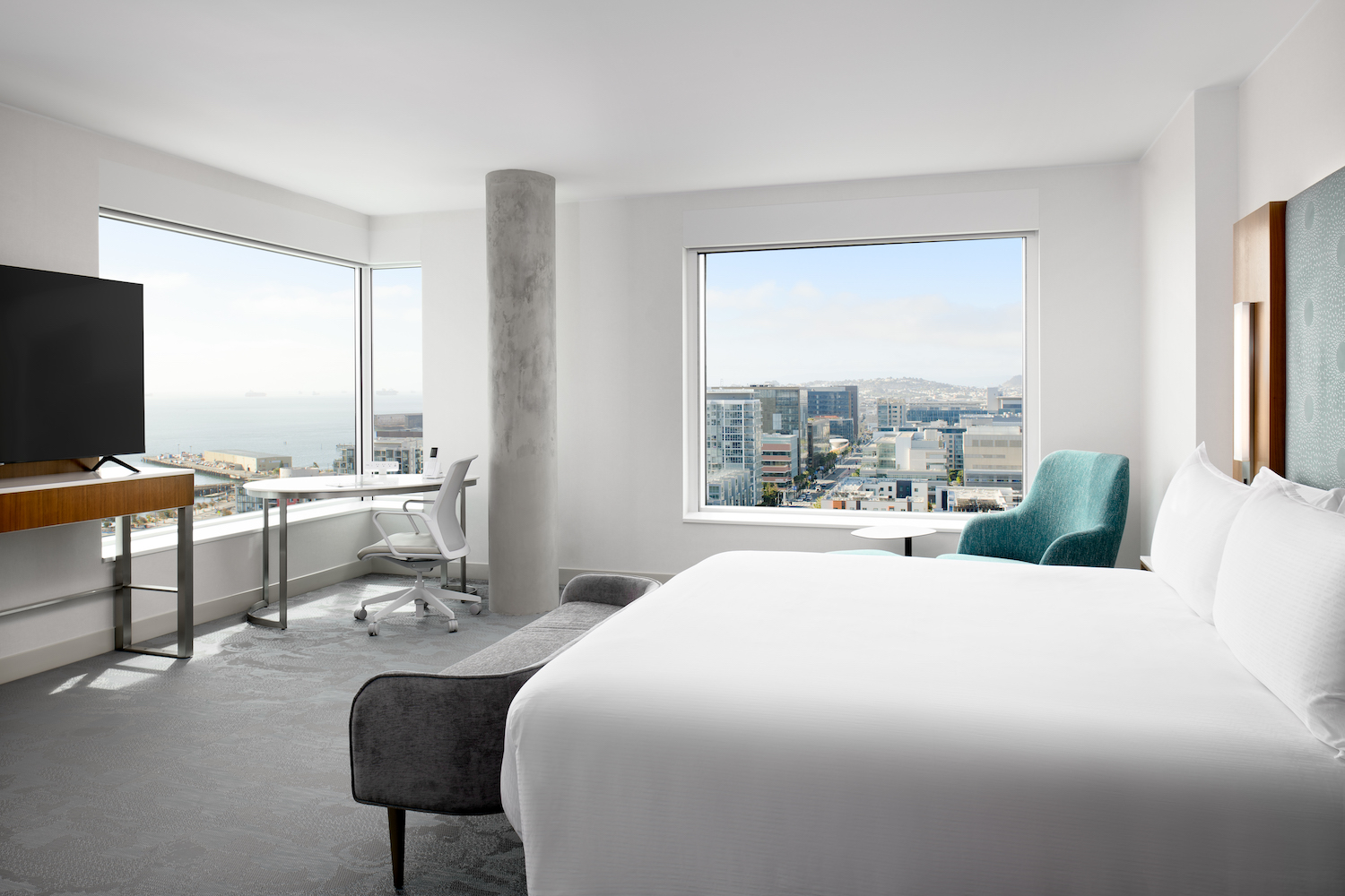 Bedroom with city view out of the window at LUMA Hotel San Francisco